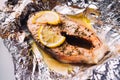 Fish steak baked with lemon and herbs in foil