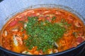 Fish stew being cooked boiling in traditional large pan