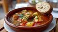 Fish stew with vegetables and bread in a rustic bowl. Royalty Free Stock Photo