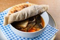 Fish stew in a white bowl, served with a pita bread cover on top. Levantine East Mediterranean food