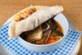 Fish stew in a white bowl, served with a pita bread cover on top. Levantine East Mediterranean food