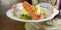 Fish stick with mashed potatoes and green peas served by waiter in restaurant or diner Royalty Free Stock Photo