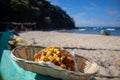 A fish taco in a basket sitting on the edge of a boat on the beach