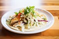 fish taco with cabbage slaw and white sauce on a corn tortilla