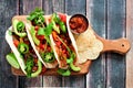 Fish tacos with watermelon salsa and avocados on a wood paddle board