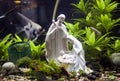 A fish tank decorated wiha a Christmas statuette.