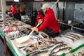 fish vendor at a seafood market in Washington puts ice on the counter