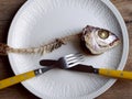 Fishbone with fork and knife in a beautiful plate