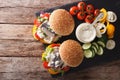 Fishburger with herring, gravy and fresh vegetables close-up. Ho Royalty Free Stock Photo