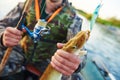 Fisher with catch pike on river Royalty Free Stock Photo