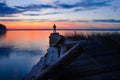 Fisher on evening old pier on the lake at sunset Royalty Free Stock Photo
