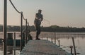 Fisher fishing in foggy morning. Man with fish rod resting on lake in mist Royalty Free Stock Photo