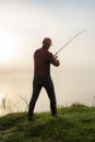 Fisher fishing on the shore of lake