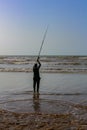 A Fisher man holding his hook with his fisher rod with a beautiful sunset