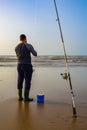 A Fisher man holding his hook with his fisher rod with a beautiful sunset