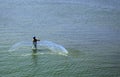 Fisher man throw a net on the sea backwater