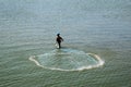 Fisher man throw a net on the sea backwater