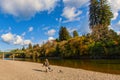 Fisher man walking with gear along Russian River over rocky beach Royalty Free Stock Photo