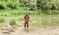 Fisher masculine hobby. Fish on hook. Brutal man wear rubber boots stand in river water. Satisfied fisher. Fishing Royalty Free Stock Photo