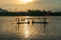 Fisher men fishing on a fishing boat in river in Mekong Delta on floating water season at sunset Royalty Free Stock Photo