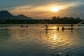 Fisher men fishing on a fishing boat in river in Mekong Delta on floating water season at sunset Royalty Free Stock Photo