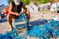 Fisher piles up and cleans fishing net at sandy beach