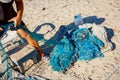 Fisher piles up and cleans fishing net at sandy beach
