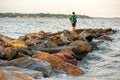 Fisher on the rock beach in East Greenwich, Rhode Island on sunset