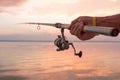 Fisher's hands holding reel, fishing at the sunset Royalty Free Stock Photo