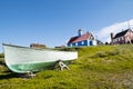 Fisherboat Sisimiut, Greenland. Colorful wooden boat on green summer meadow with wooden colorful houses