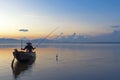 Fisherman action when fishing on lake in the sunshine morning and silhouette fisherman on the boat,