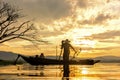 Fisherman action when fishing net on lake in the sunshine morning and silhouette fisherman outdoor on the boat, Royalty Free Stock Photo