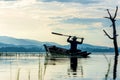 Fisherman action on lake in the sunshine morning and silhouette fisherman outdoor on the boat,