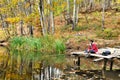 Fisherman in autumn forest catches the fish in the lake Royalty Free Stock Photo