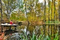 Fisherman in autumn forest catches the fish in the lake Royalty Free Stock Photo