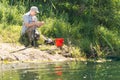 Fisherman baiting his hook on a lake shore