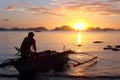 Fisherman in a banka, traditional filipino boat, at sunset, the Philippines