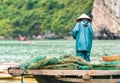 A fisherman in the bay is catching fish, Halong, Vietnam. Copy space for text. Back view.
