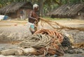 Fisherman on a beach collecting ropes Royalty Free Stock Photo