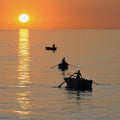 Fisherman on beautiful calm bay at sunrise