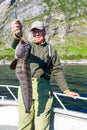 Fisherman with big wolffish near Lofoten, Senija, Alta Norway. Man holding catch Atlantic wolf fish Royalty Free Stock Photo