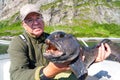 Fisherman with big wolffish near Lofoten, Senija, Alta Norway. Man holding catch Atlantic wolf fish Royalty Free Stock Photo