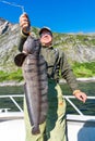 Fisherman with big wolffish near Lofoten, Senija, Alta Norway. Man holding catch Atlantic wolf fish Royalty Free Stock Photo