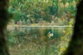 Fisherman in boat in automn day. fishing on lake inside the forest