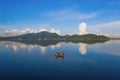 Fisherman with boat in Bang Pra Reservoir dam. National park with reflection of river lake, mountain valley hills in Sri Racha,