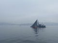 Fisherman boat with a big huge fishnet collecting fish from the bosphorus early morning in mist.
