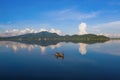 Fisherman on a boat for fishing and catching freshwater fish in nature lake or river with reflection in morning time in Asia in Royalty Free Stock Photo