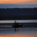 Fisherman, boat, fishing rod, over lake, France, Sunset Royalty Free Stock Photo