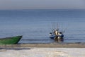 Fisherman with a boat and fishing rods on the shore of the Baltic Sea on a sunny day in the city of Klaipeda, Lithuania