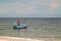 Fisherman boat float in the sea ocean near sand beach shore with hazy blue sky background landscape